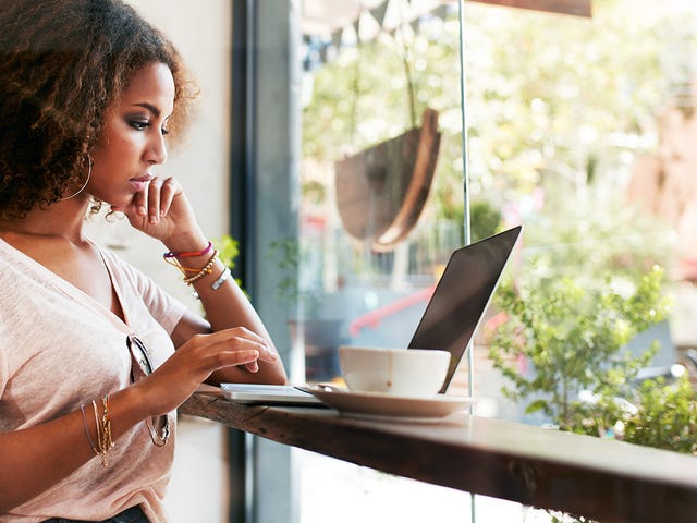 Woman sitting by the the window and attending an online intensive language class with Berlitz Algeria on her laptop