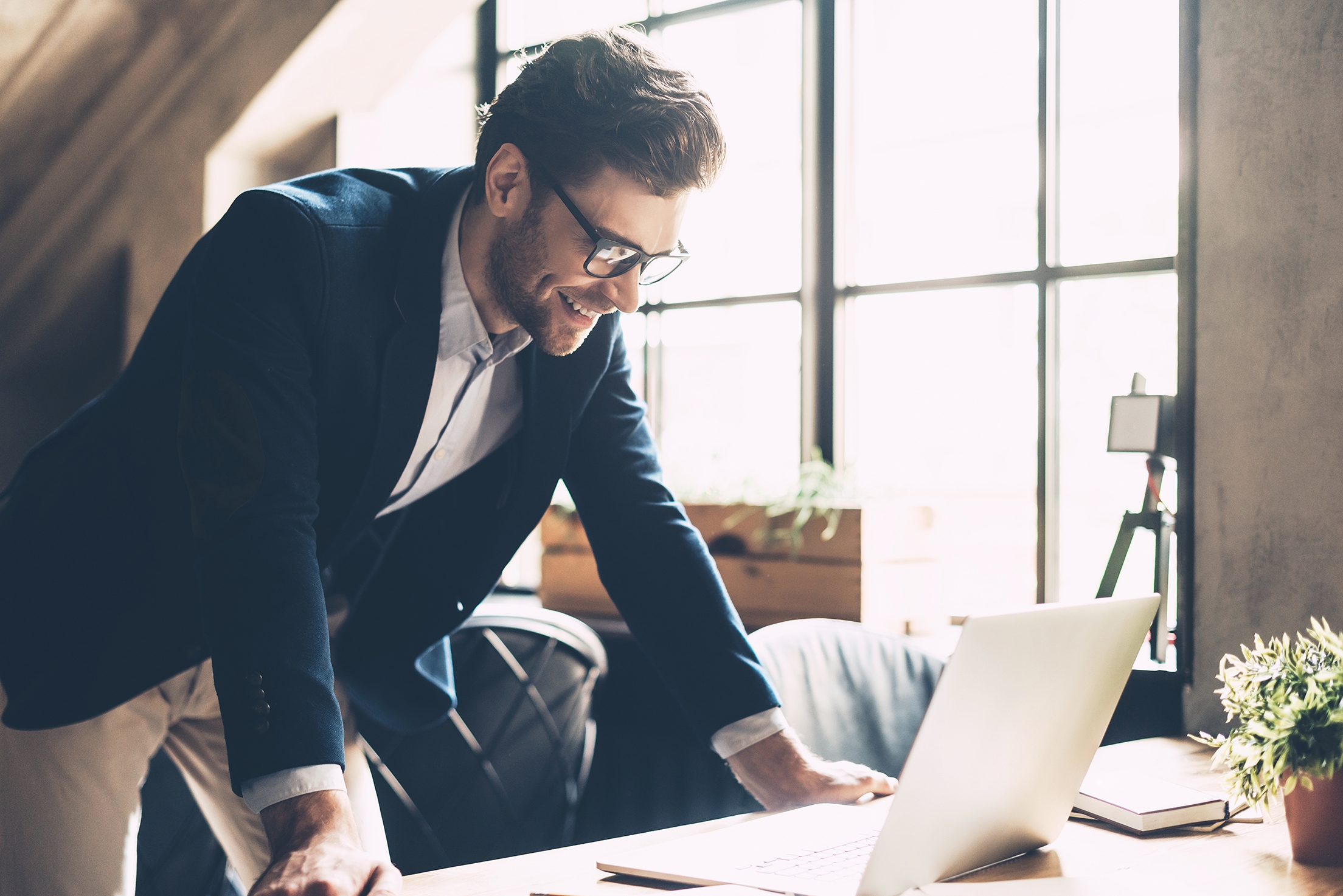 Man attending an online French class from his laptop and smiling