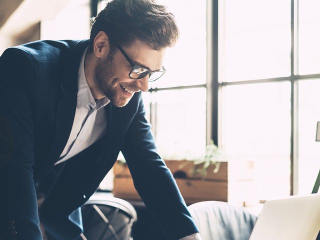Man attending an online French class from his laptop and smiling