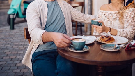 Man and woman drinking coffee and chatting after their French class with Berlitz Algeria