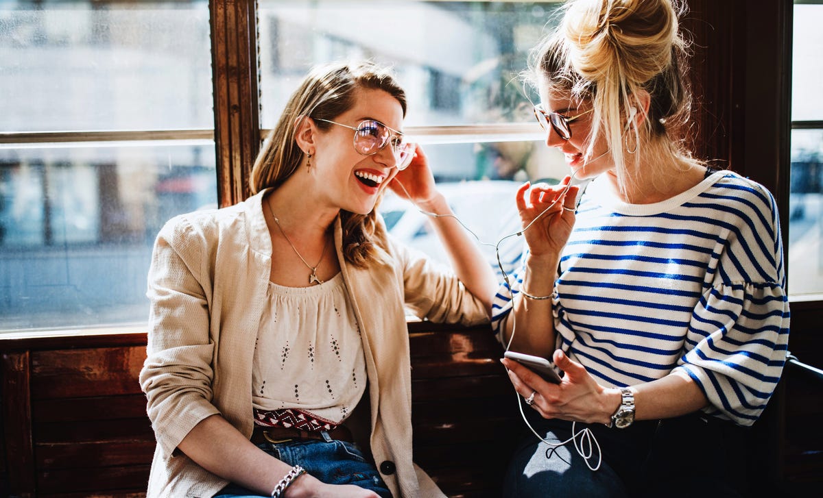 Women listening to music together and talking about Berlitz