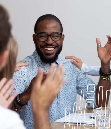 A young man smiling with people around him clapping and cheering that he has insurance with St. Luke's - A young man is smiling with people around him, clapping and cheering.