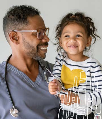 A doctor holds a little smiling girl as she plays with his stethoscope. Cover all your bases with St. Luke's Health Plan