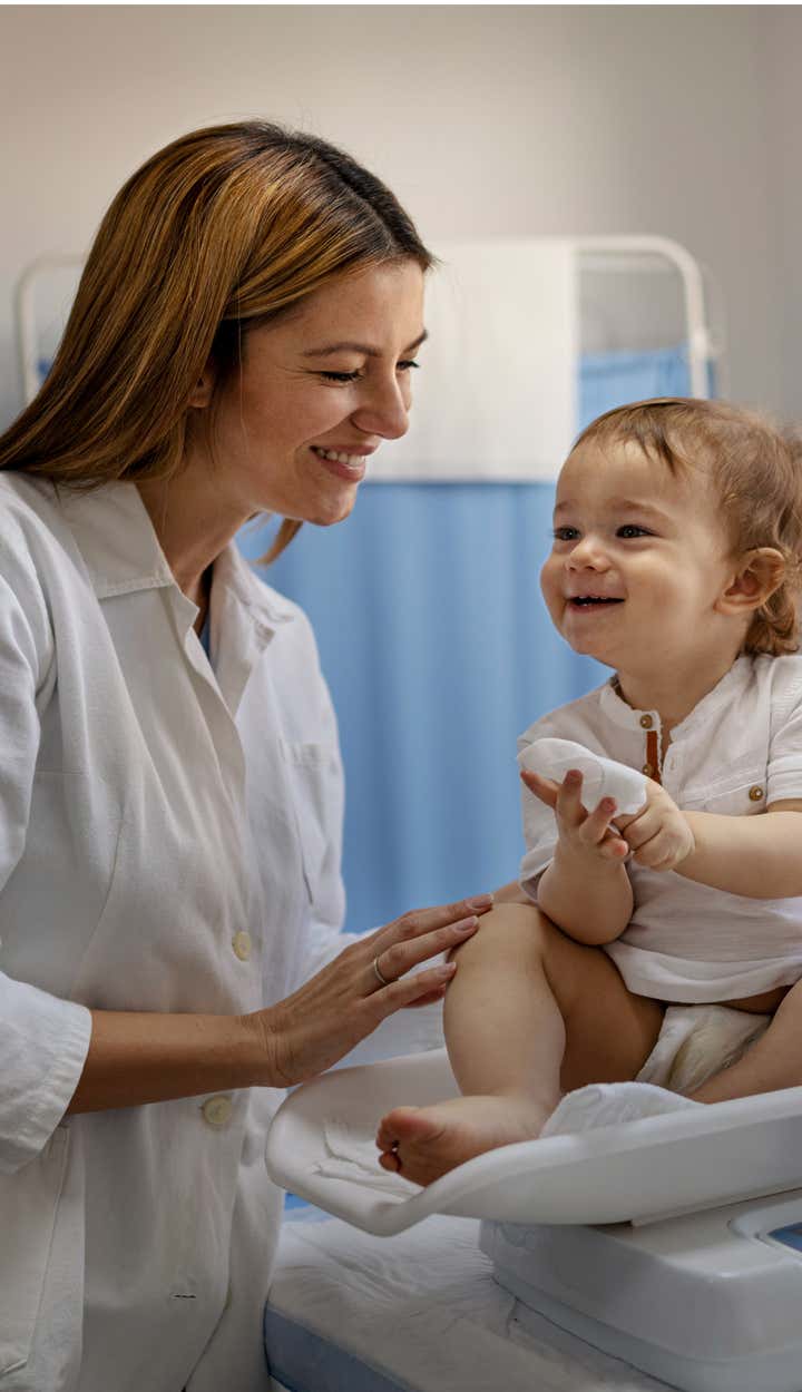 Health care professional tends to smiling toddler with St. Luke's Health Plan check up's are made worry-free.