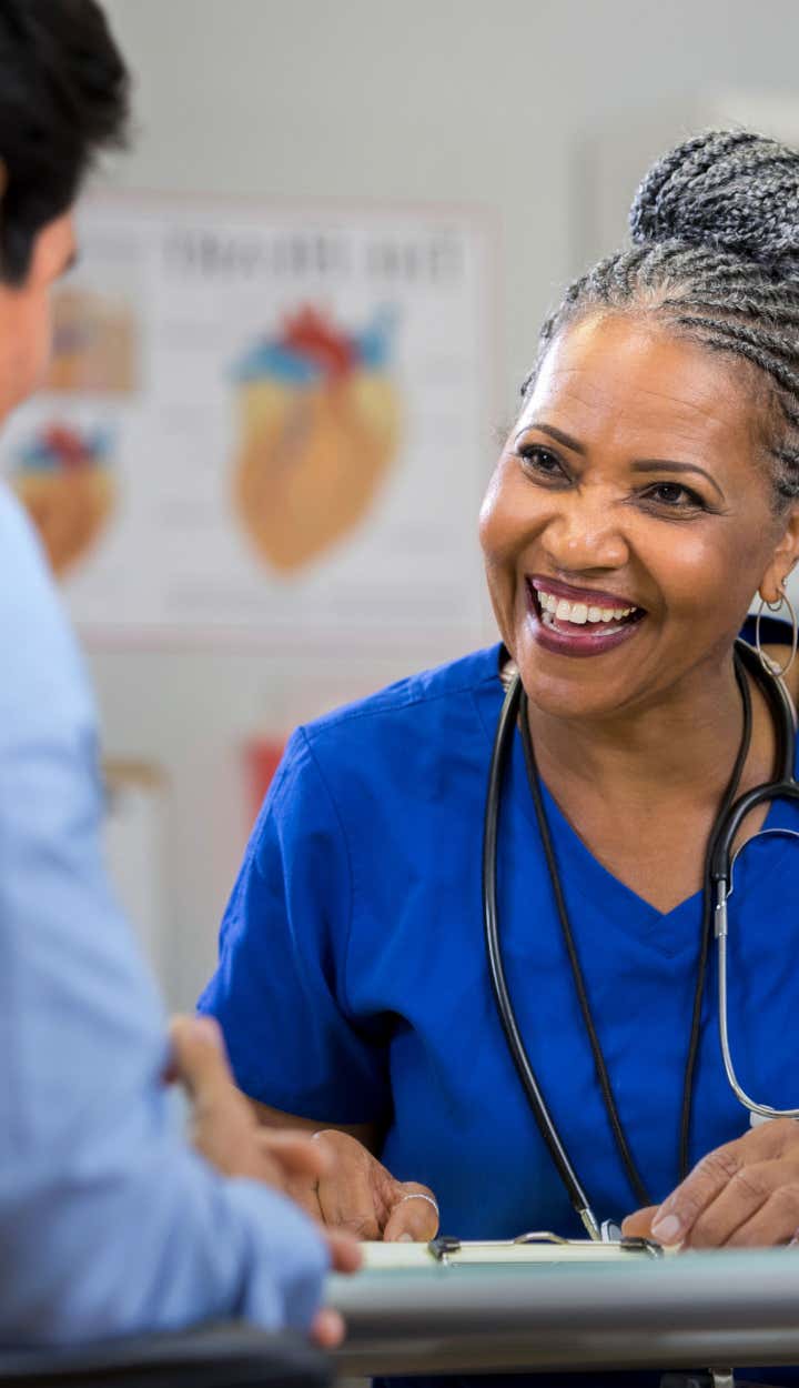 The doctor smiles as she talks to her patient about his options with St. Luke's Health Plan.