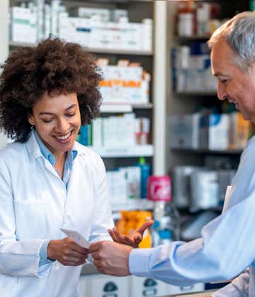 A pharmacist happily provides information about their prescription to a St. Luke's patient.