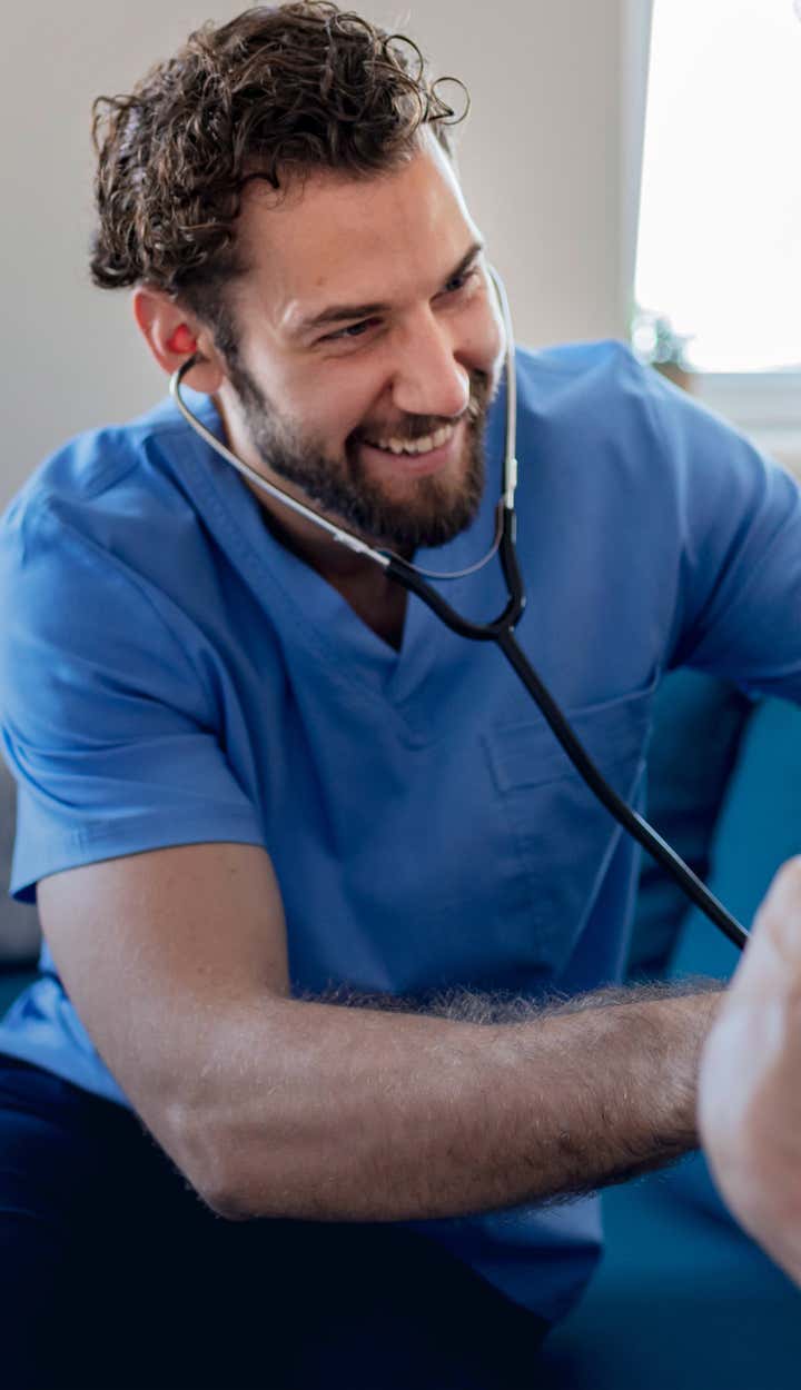 Health care professional tends to smiling older man with St. Luke's work together to provide the best care.