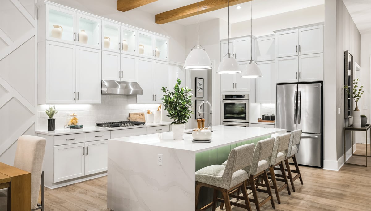 white kitchen with white counter tops and white pendant lights. 