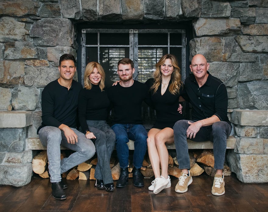 Mother and Father with their 3 children next to a fireplace