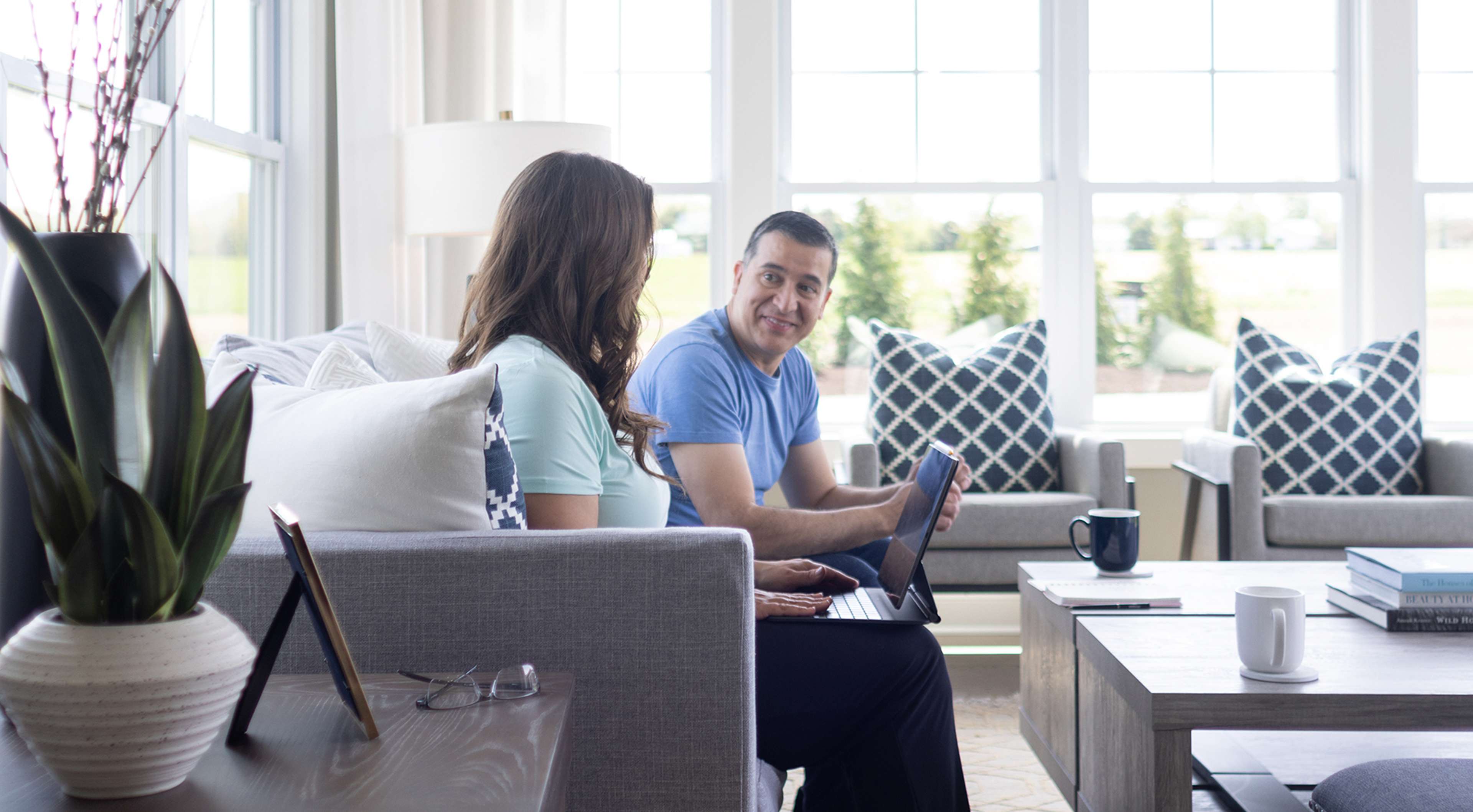 Couple in living room looking at computer. 