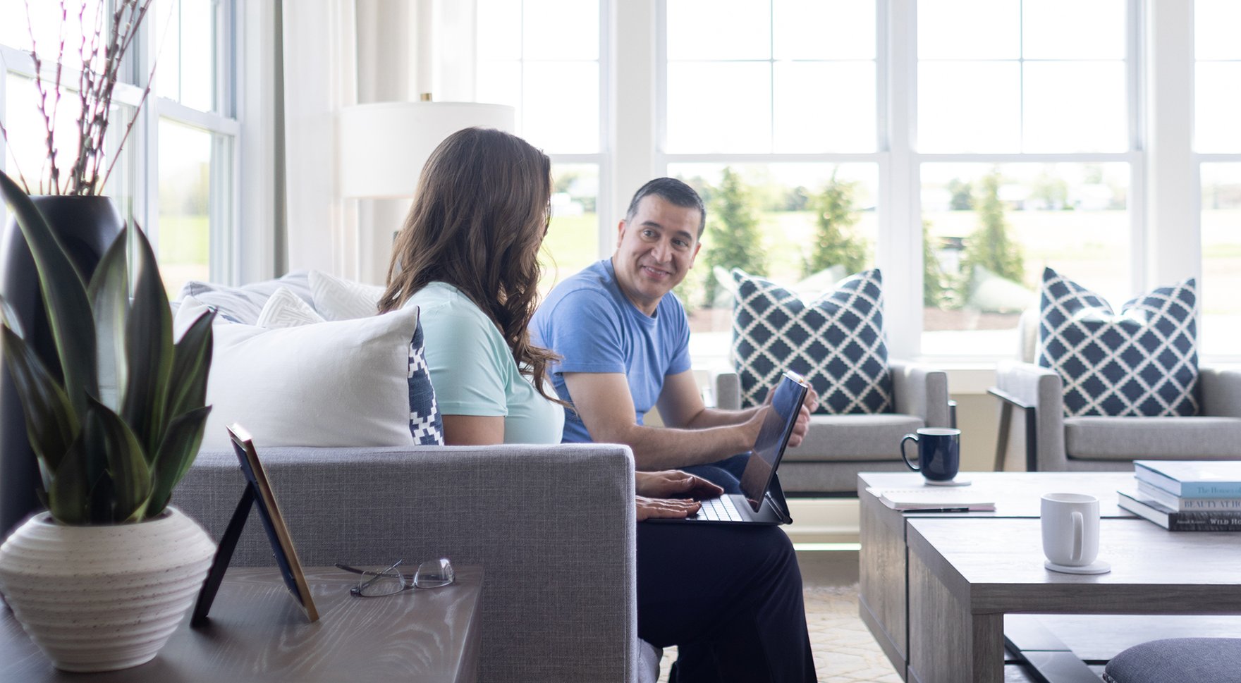Couple in living room looking at computer. 