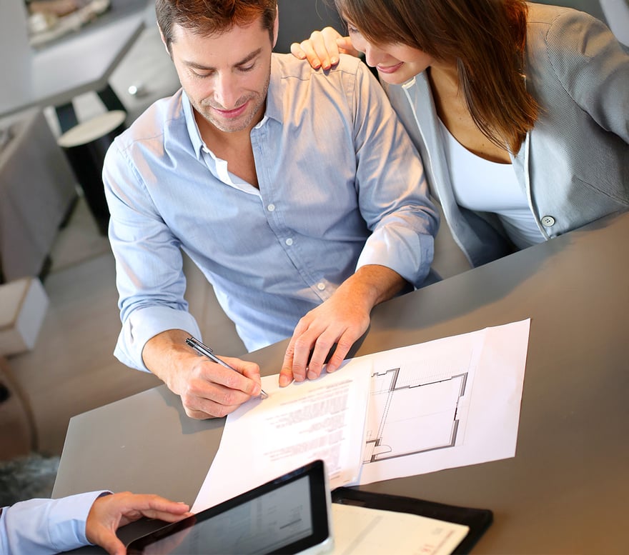 A couple reviewing a contract for purchase of a newly built home. 