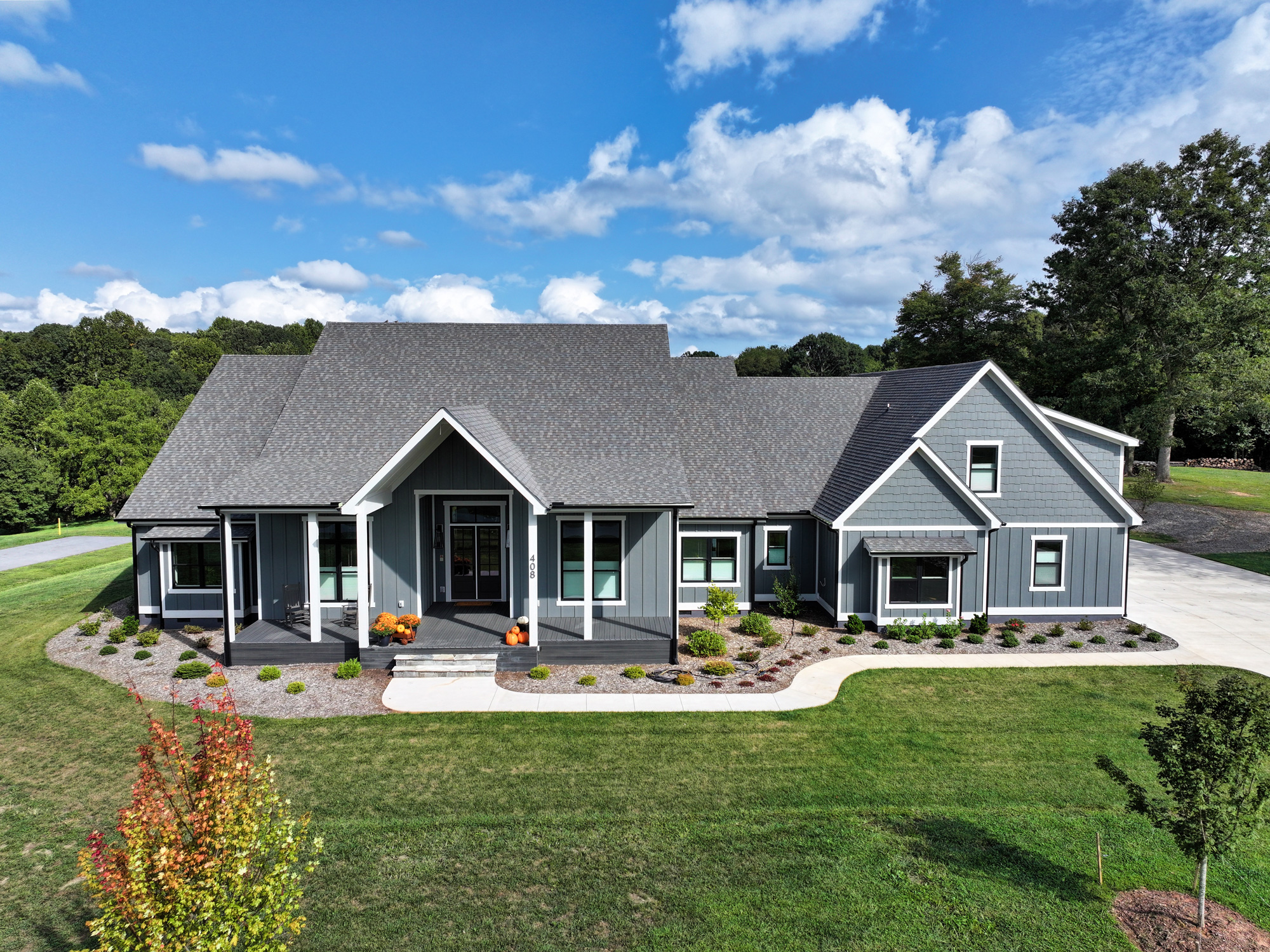 front view of a blue house on green grass on a sunny day