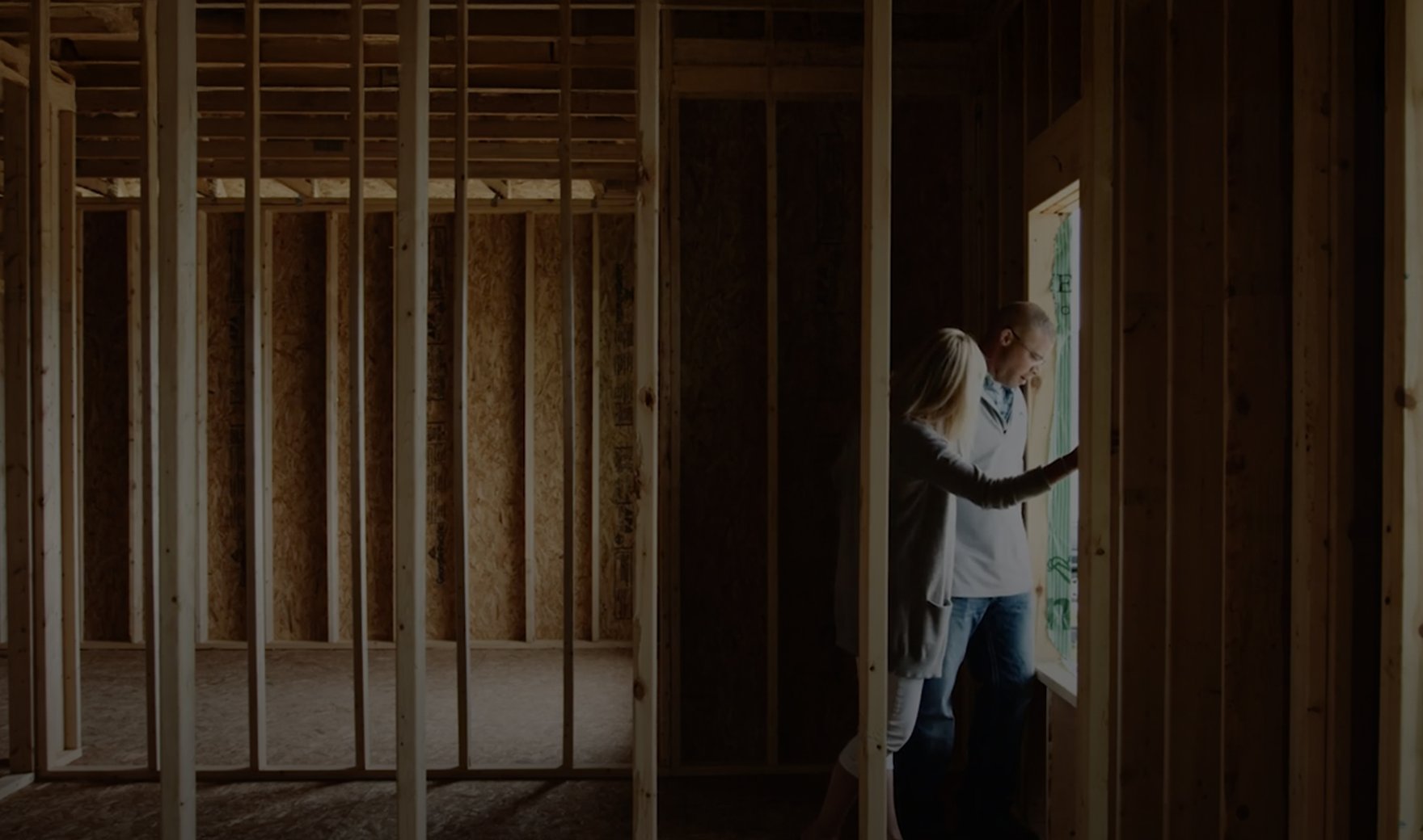 Couple walking through an under construction home.