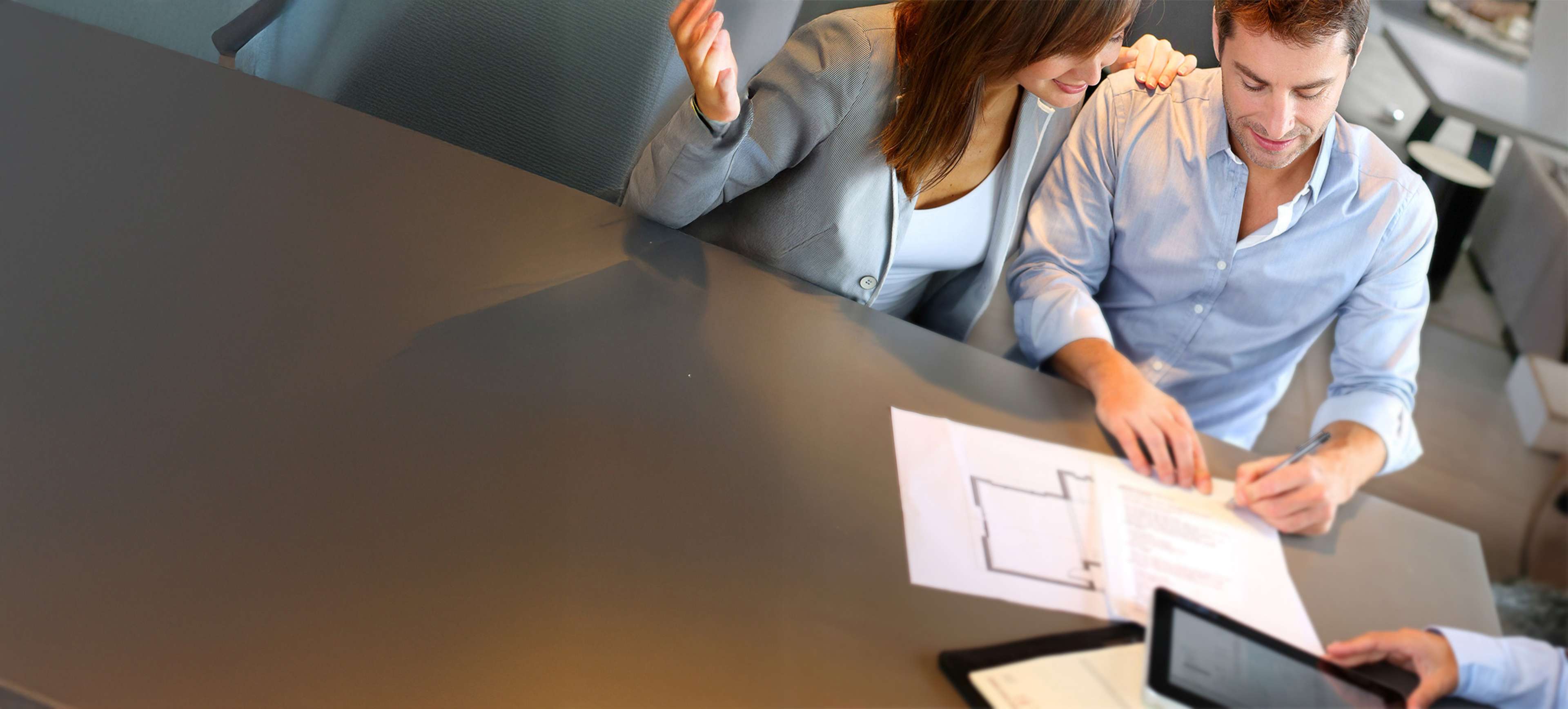 Woman sitting and looking at house plan print.