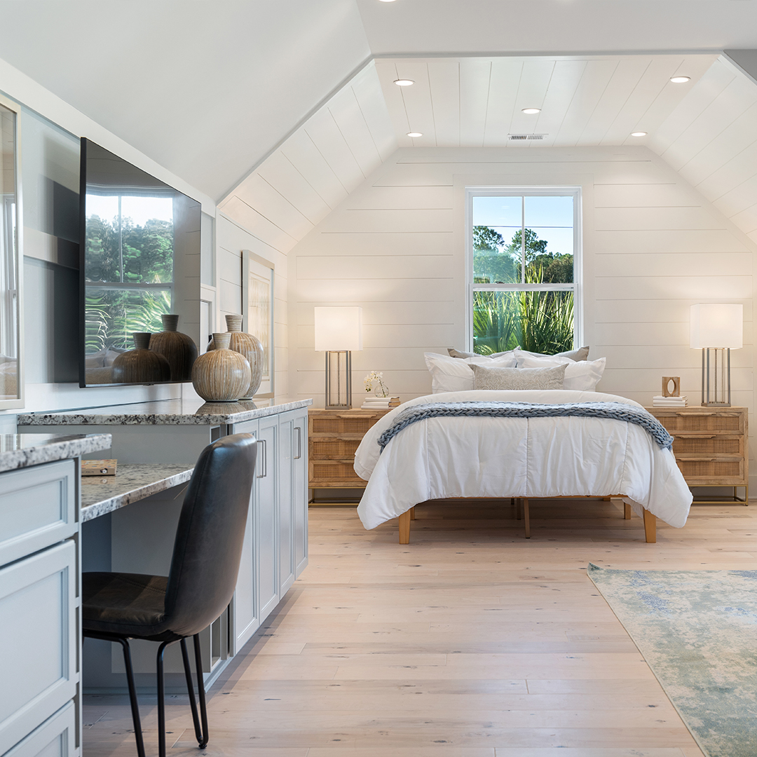 Bedroom in a house, complete with a desk and a view of the outside, evoking a sense of warmth and domesticity. The scene suggests a comfortable and productive living space.