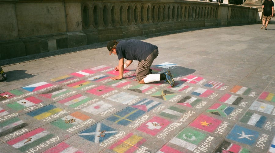 Un hombre pintando banderas del mundo