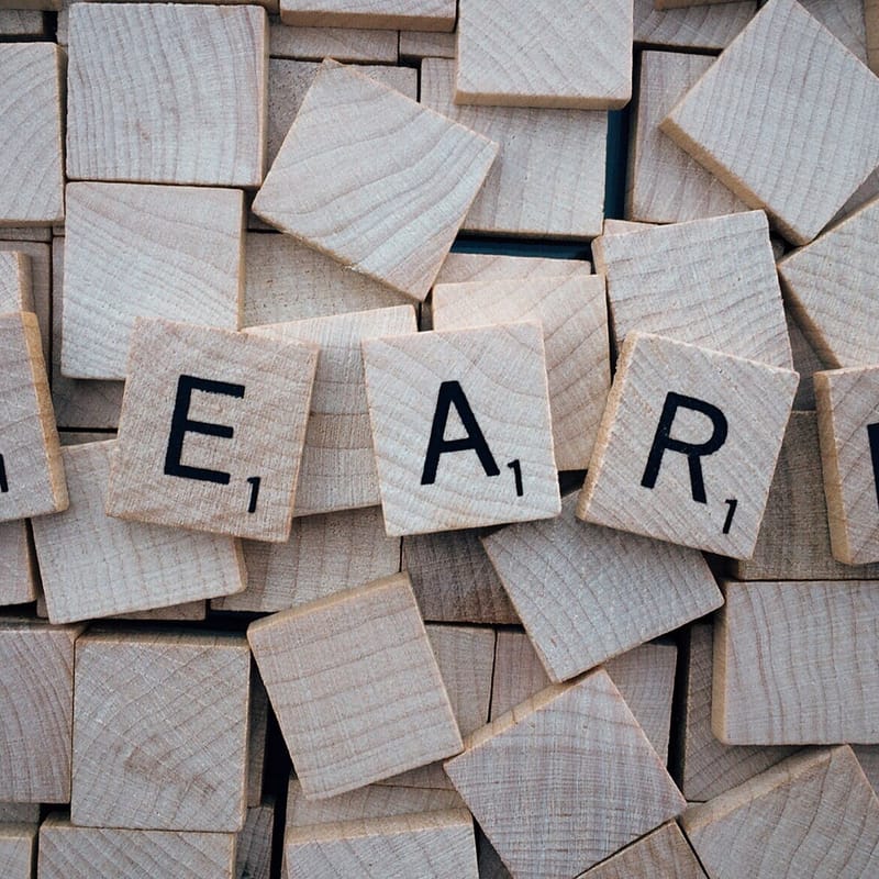 Letras del abecedario en inglés talladas en madera que forman la palabra "learn".