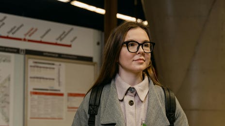 Mujer en el metro esperando para ir a su curso de inglés en el extranjero.