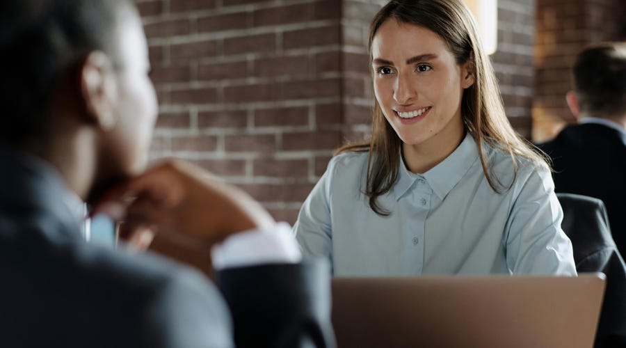Mujer dueña de una empresa tomando un café mientras busca opciones para el aumento salarial de sus empleados.