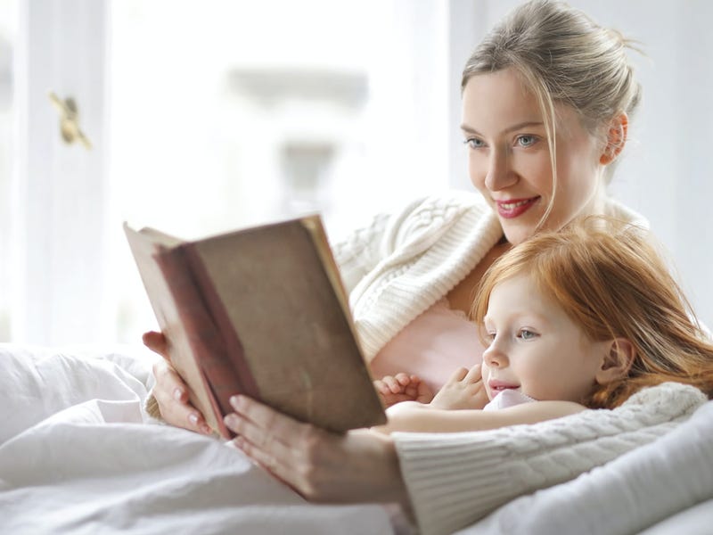 Una mujer leyéndole un cuento a su hija