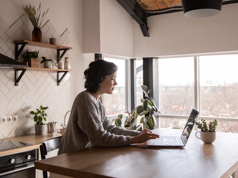 Persona trabajando de manera remota desde su cocina