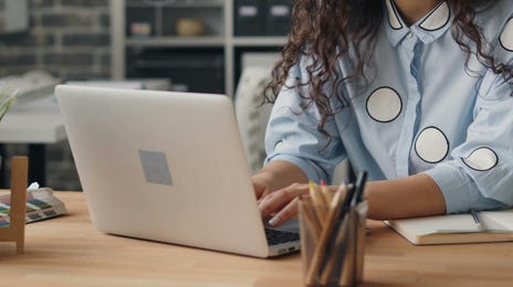 Mujer feliz escogiendo su curso entre las opciones flexibles online.