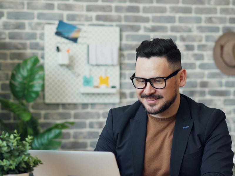 Hombre trabajando con su computadora en el teletrabajo.