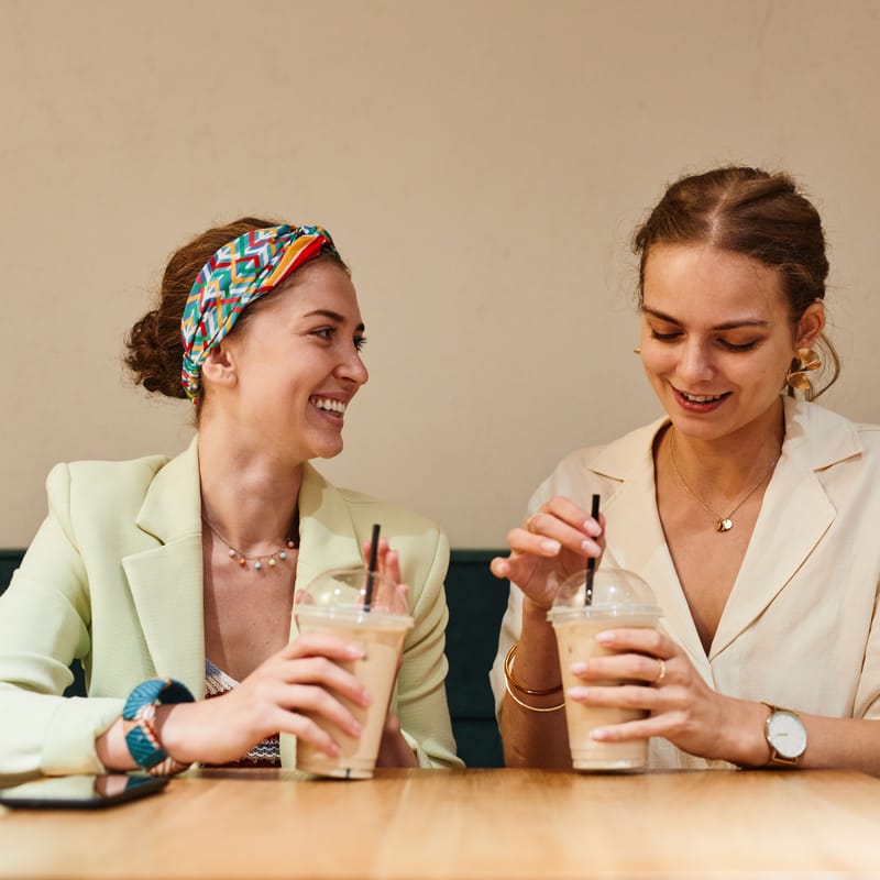 Dos mujeres riendo mientras practican el small talk en inglés.
