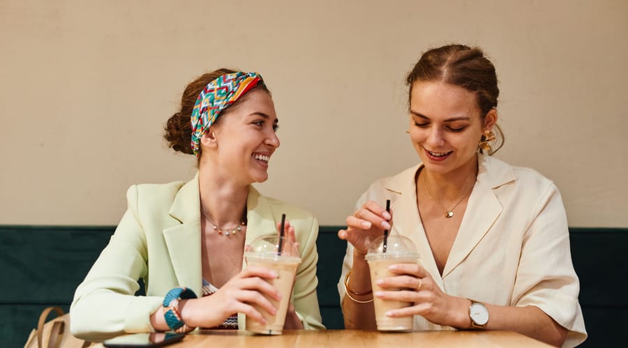 Dos mujeres riendo mientras practican el small talk en inglés.