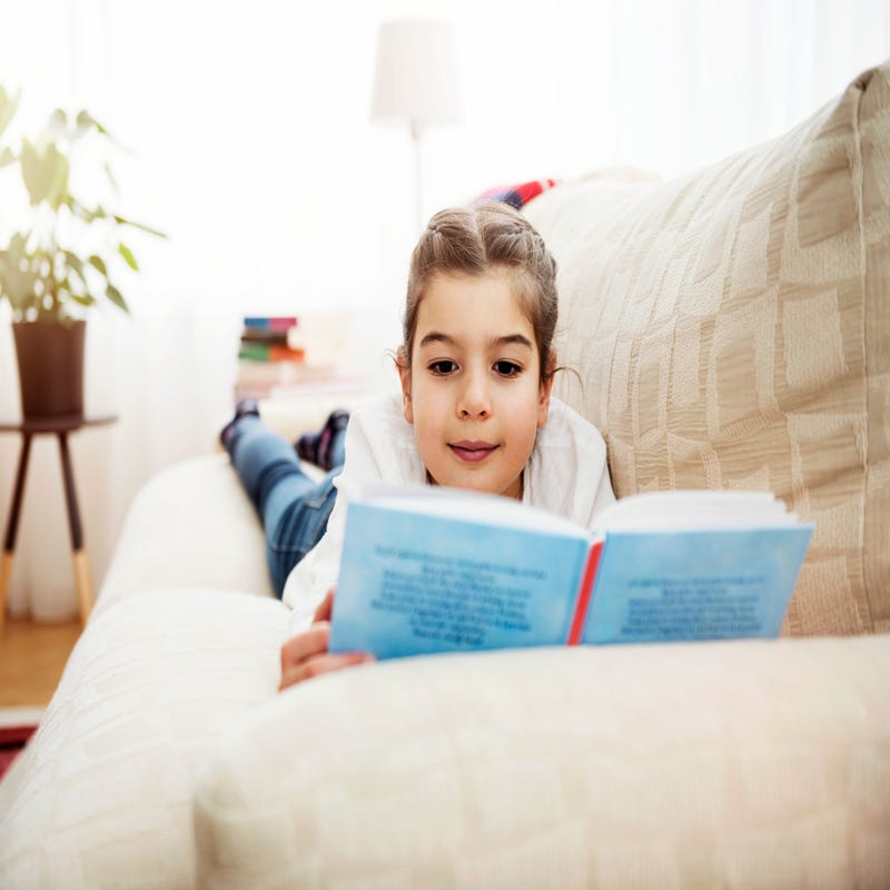 Niña leyendo viendo actividades para niños en casa durante las vacaciones de navidad