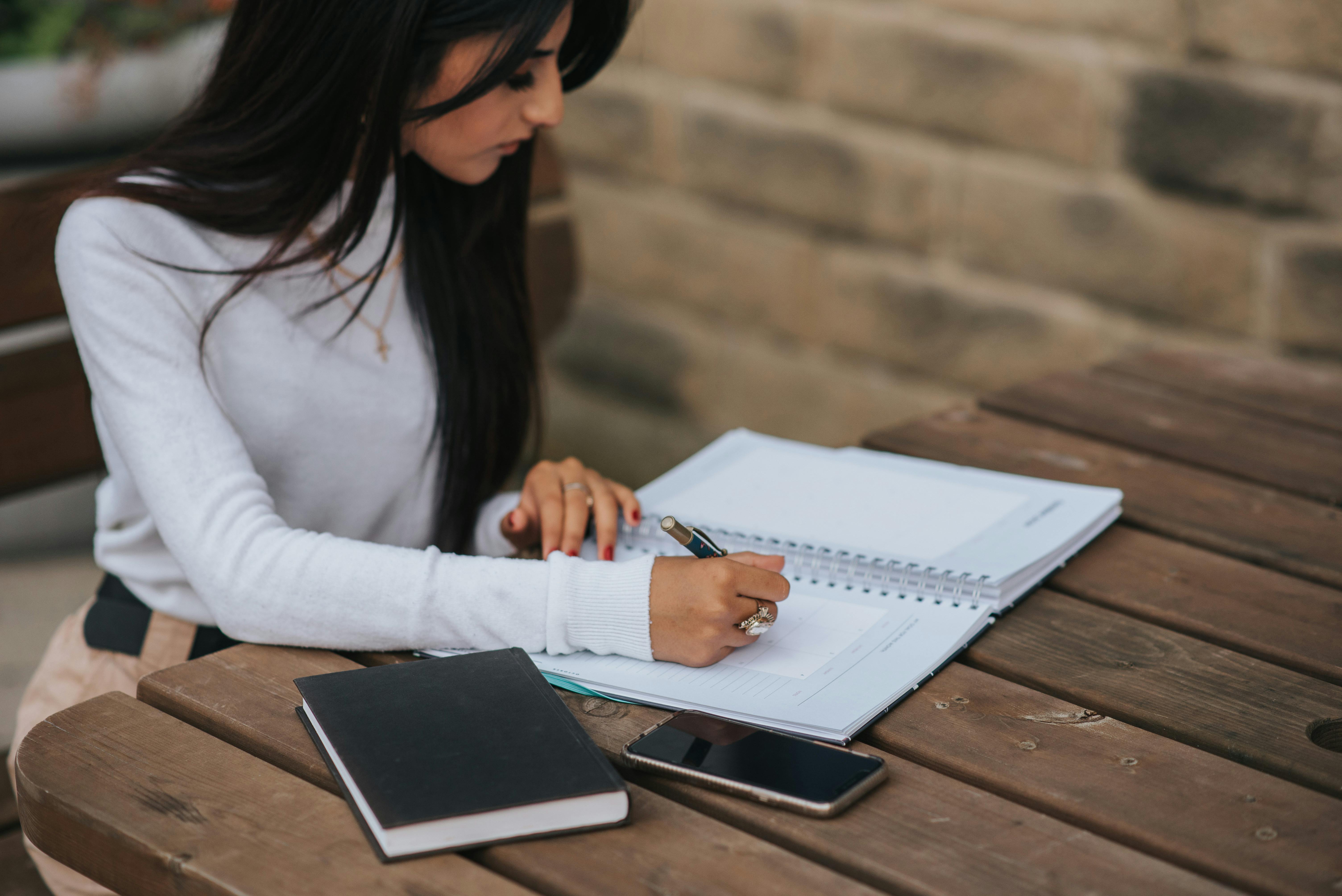 Mujer estudiando temas de inglés a1 con un cuaderno.