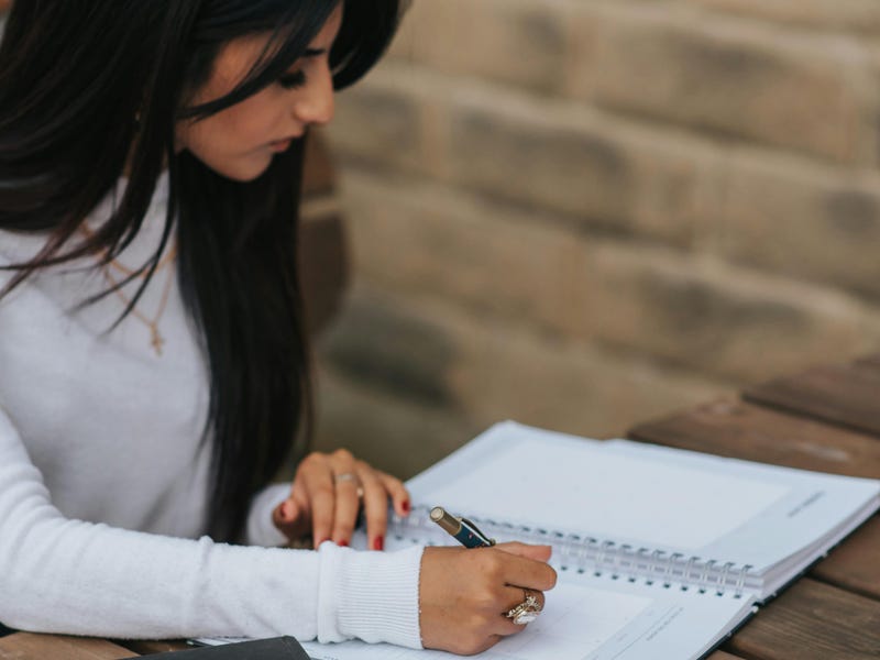 Mujer estudiando temas de inglés a1 con un cuaderno.