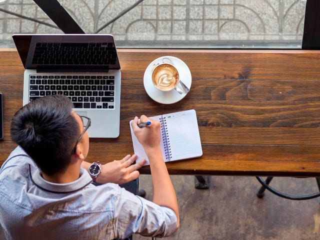 Hombre presentando examen de francés en su computador portátil desde una cafetería, con apoyo de Berlitz