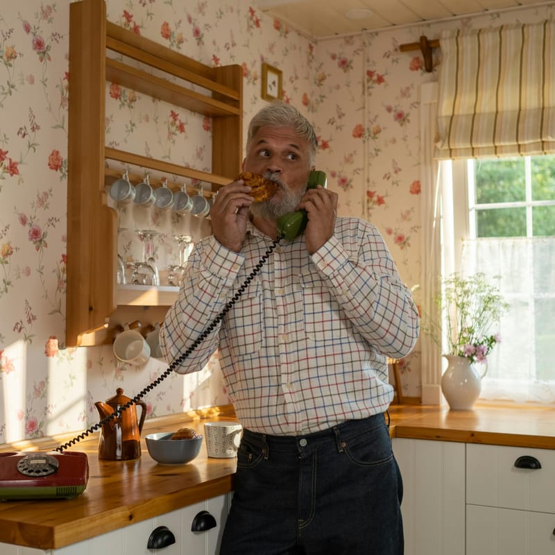 Hombre explicándole a su novia el uso de used to a través de un teléfono fijo antiguo.