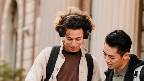 Dos estudiantes conversan mientras revisan sus actividades del curso de idiomas en Berlitz. Aprender inglés con un enfoque práctico y colaborativo.
