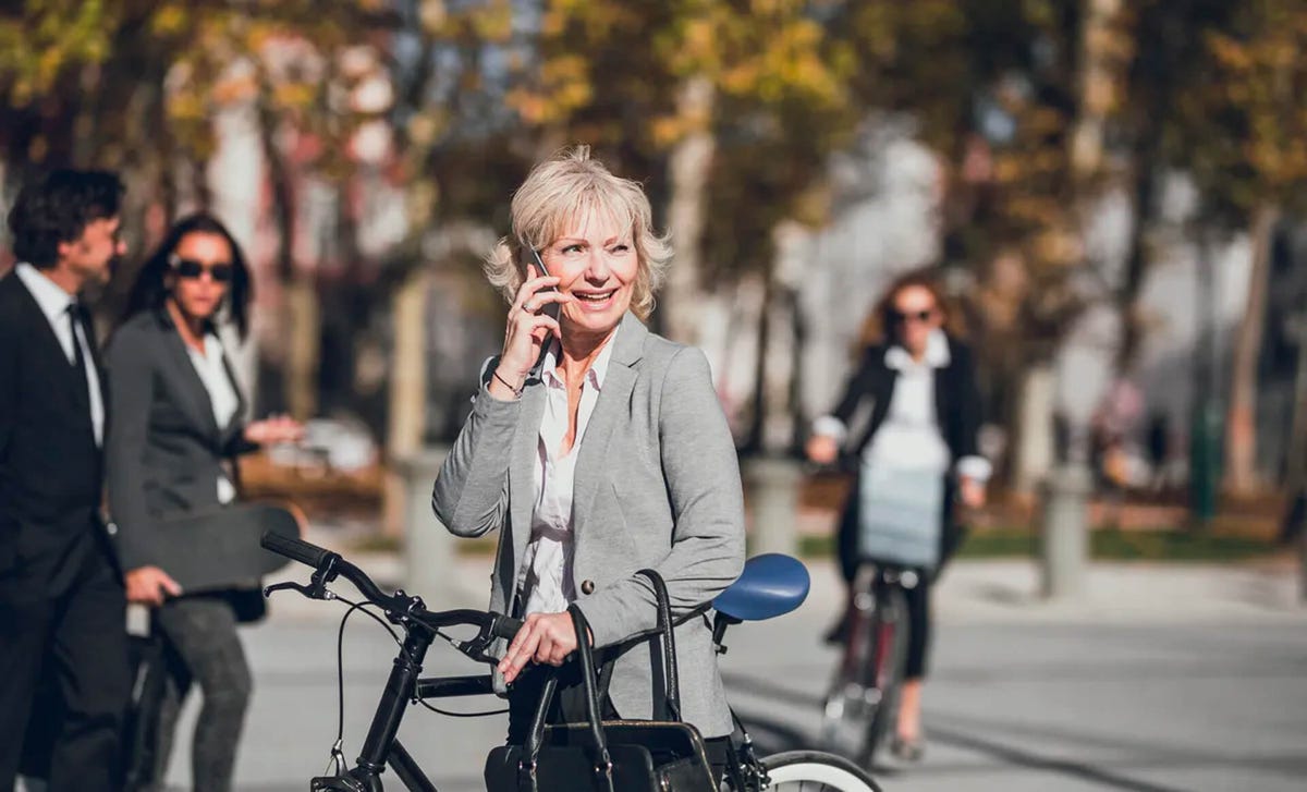 Mujer adulta sonriente hablando por teléfono tras contactar al centro de idiomas Berlitz.
