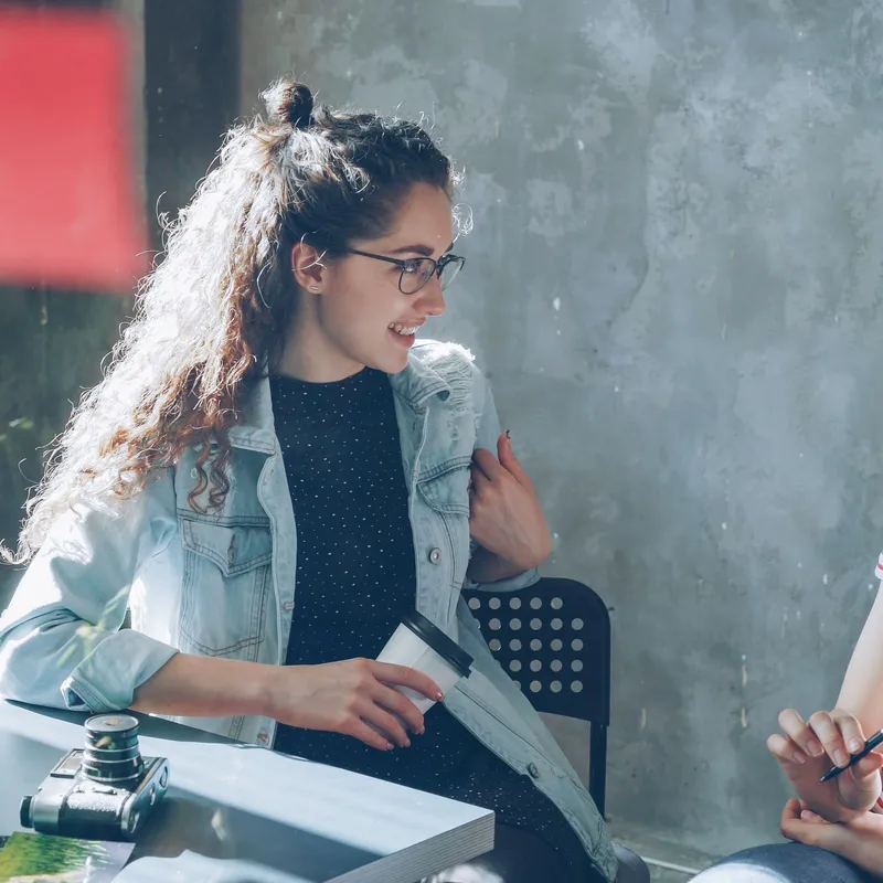 Dos mujeres hablando sobre la diferencia entre introvertido y extrovertido en el aprendizaje.