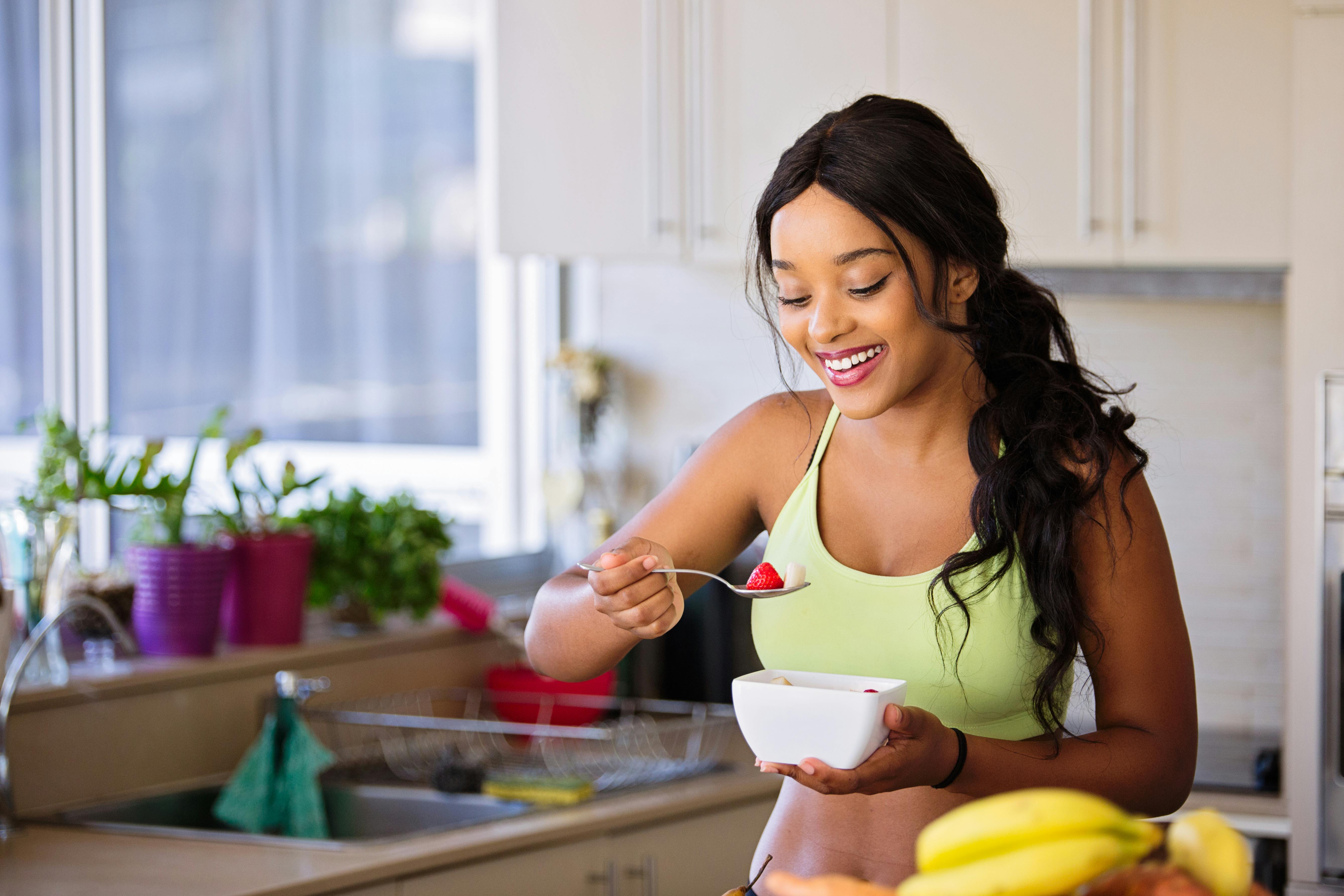 Mujer con un bowl de frutas para empezar sus hábitos saludables.