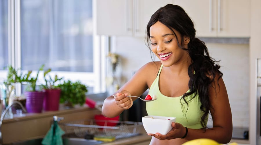 Mujer con un bowl de frutas para empezar sus hábitos saludables.