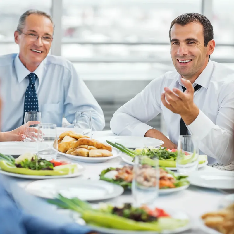 Grupo de adultos conversando en un restaurante durante una práctica de inglés con Berlitz.