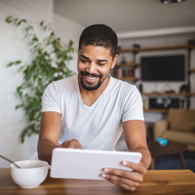 Hombre presentando su test de idiomas online con Berlitz desde la comodidad de su casa, integrando el aprendizaje a su rutina diaria.