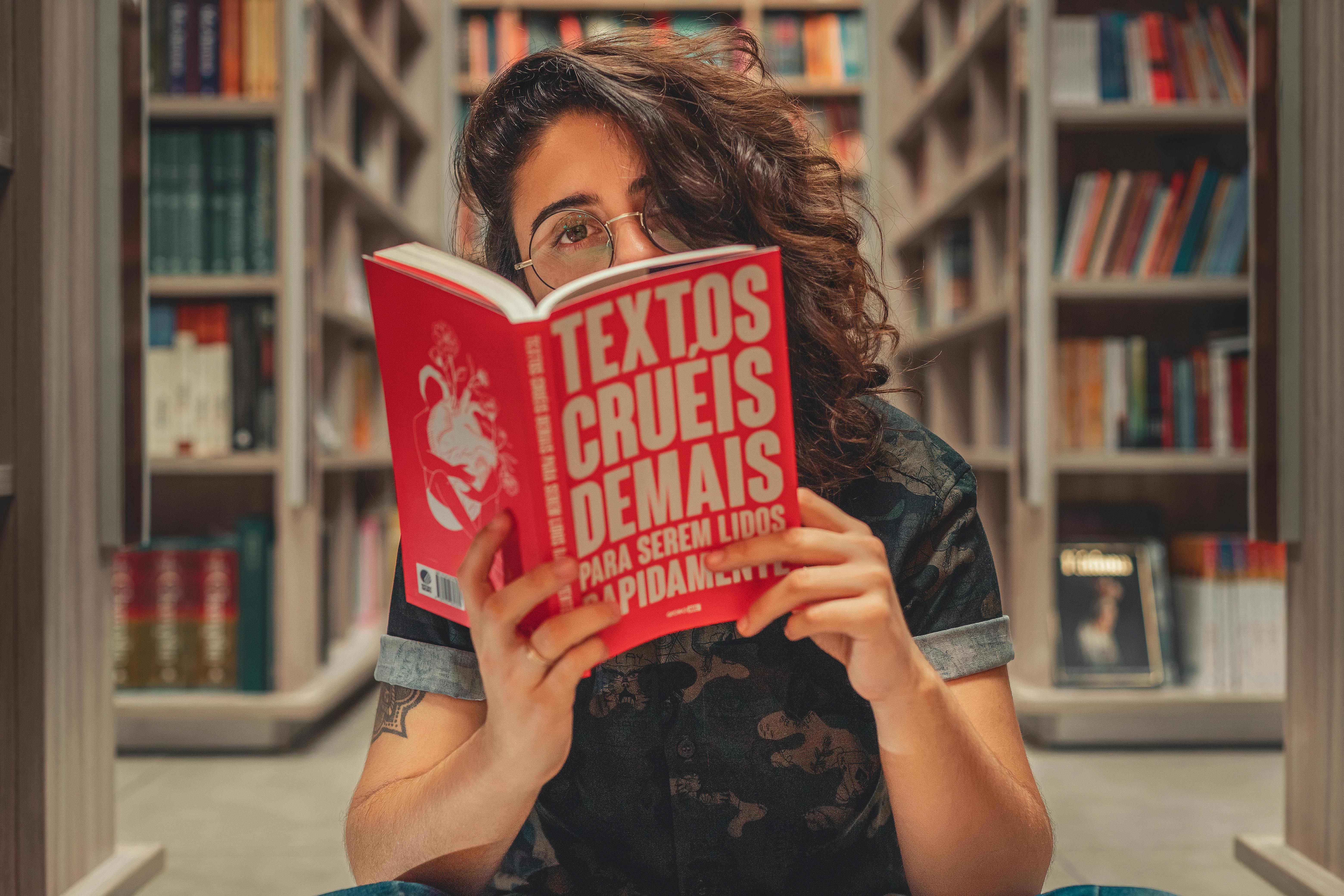 Mujer leyendo un libro en portugués para encontrar los cognados.