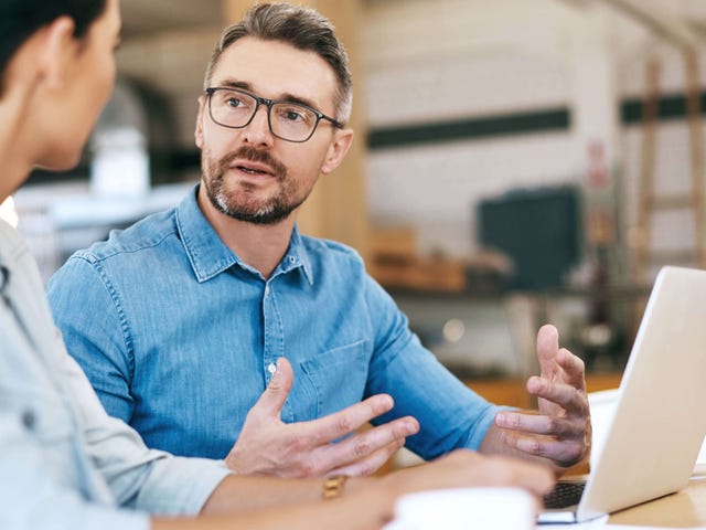 Dos profesionales discutiendo ideas y colaborando en un entorno moderno, reflejando las oportunidades de crecimiento que ofrece el aprendizaje de idiomas con Berlitz.