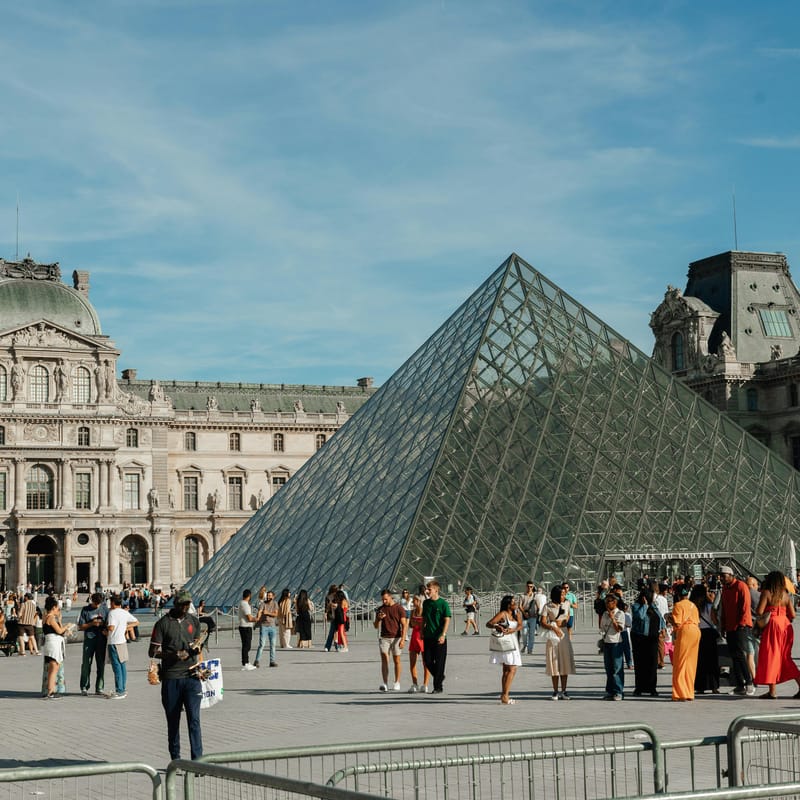 Personas caminando en París mientras piensan en estudiar con un curso de francés.