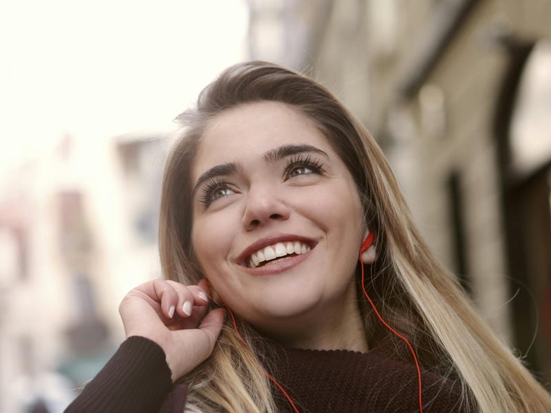 Mujer soltera con sus audífonos aprendiendo sobre los estados civiles en inglés.