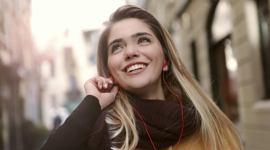 Mujer soltera con sus audífonos aprendiendo sobre los estados civiles en inglés.