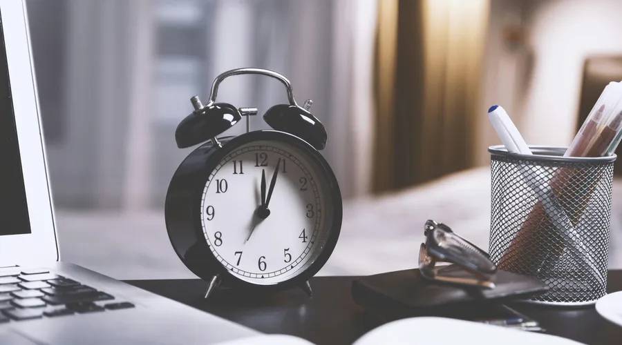 Reloj antiguo en una mesa para aprender a decir la hora en inglés.