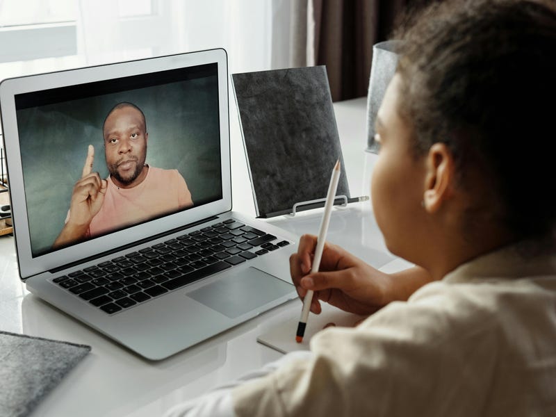 Niña estudiando con su profesor para examen de inglés.