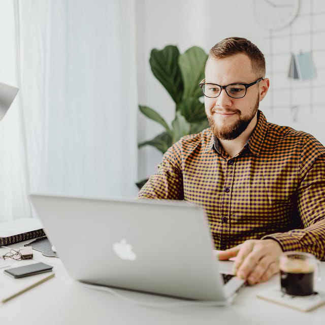 Hombre estudiando con su computadora porque cree en la educación en línea.